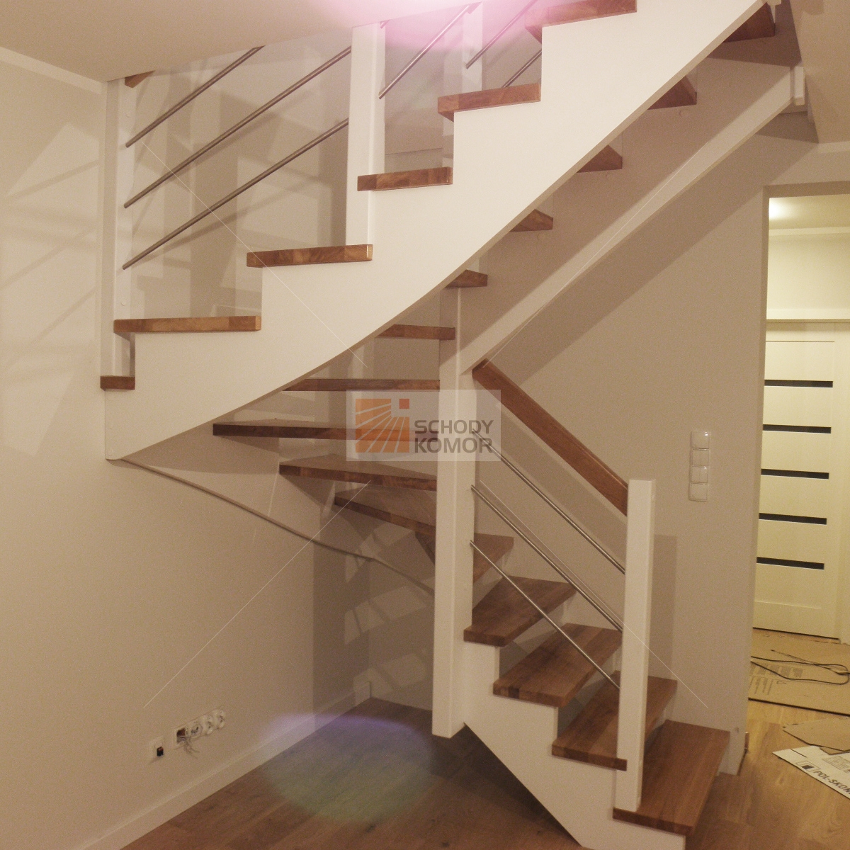 białe nowoczesne schody z metalowymi relingami z prętów