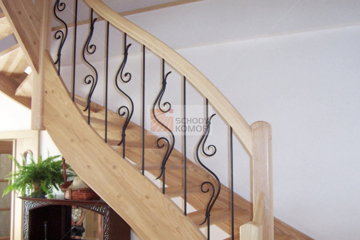 schody drewniane z wygiętą poręczą i kutą balustradą