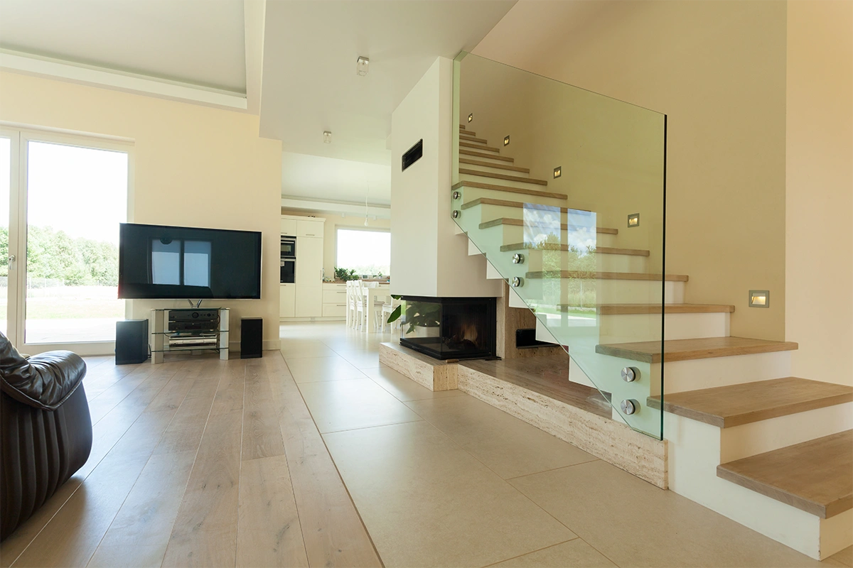 piękne schody w salonie szklana balustrada schody drewniane na beton aranżacja salonu pomysł