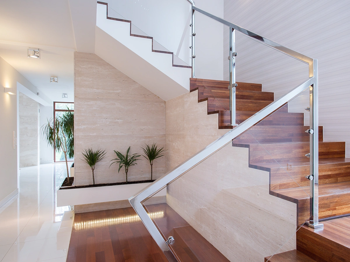 drewniane schody dywanowe ze szklaną balustradą i metalową poręczą - realizacja w Opolu