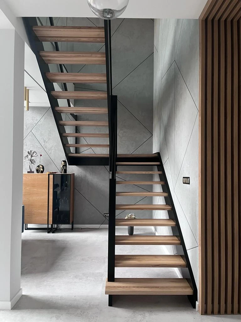 czarne schody drewniane ściana z betonu architektonicznego wnętrze nowoczesne lamele drewniane na ścianie