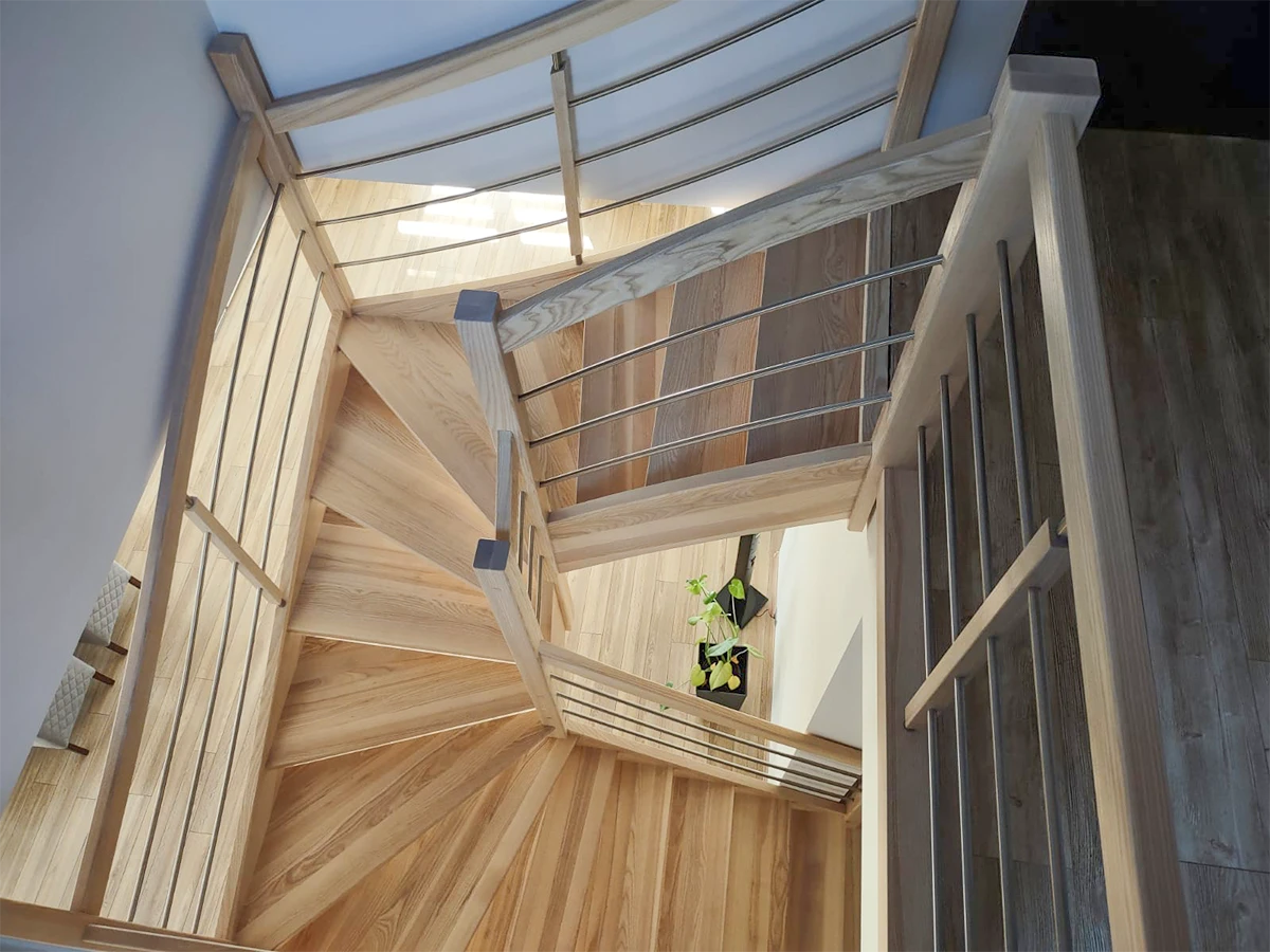 schody drewniane jesionowe dwubiegowe bez podestu spocznika w salonie