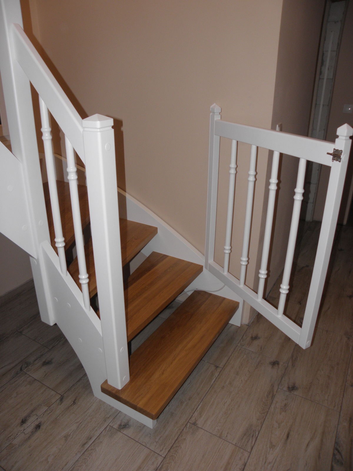 białe schody z bramką zabezpieczającą dla dzieci